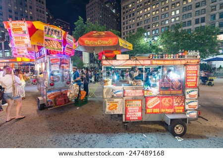 NEW YORK CITY - JUNE 12, 2013: New York street seller in a Manhattan square at night. Food sellers are all over Manhattan offering a variety of street foods.