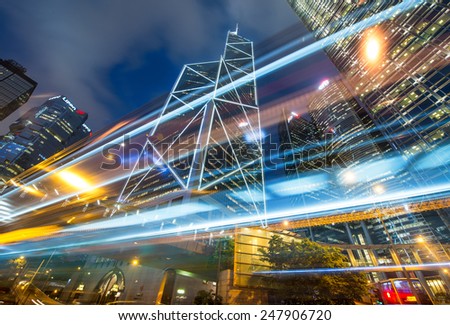 HONG KONG -  MAY 6, 2014: Cars and buses speed up in city streets at night. Public transportation is used by more of 90 percent of population.