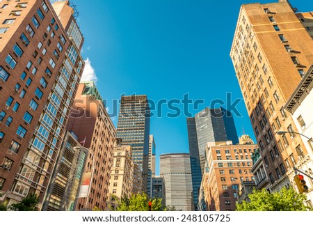 Manhattan skyscrapers with city trees, New York.