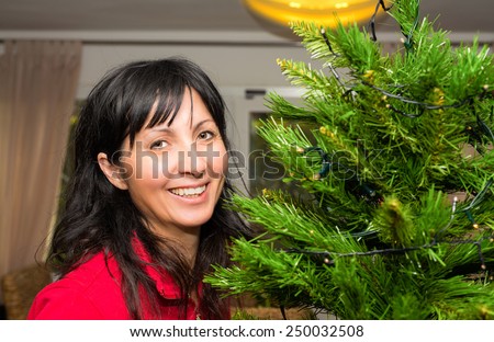Woman in 40s about to decorate Christmas tree.