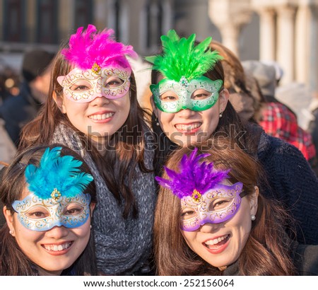 VENICE, ITALY - FEBRUARY 8, 2015: Unidentified masked asian persons in costume in St. Mark\'s Square during the Carnival of Venice 2015. The 2015 carnival started on January 31.