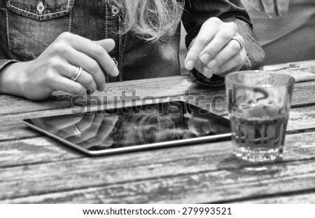 Girl using tablet with drink on the table.