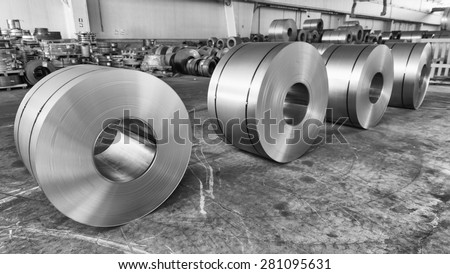 Steel coils inside industrial shed.