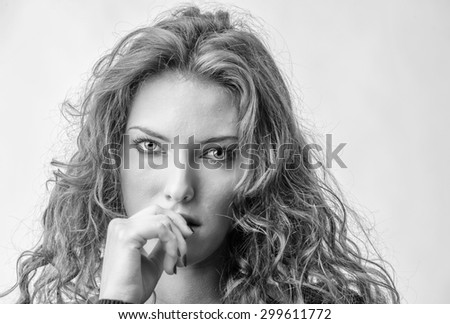Close-up portrait of beautiful seductive woman biting finger.