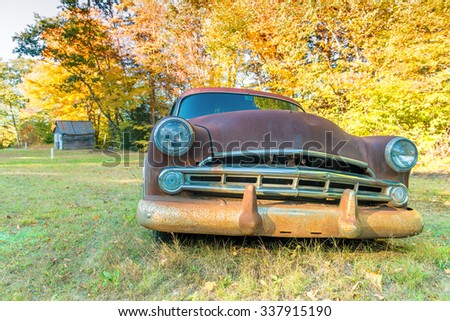 Old car wreck in a countryside field.