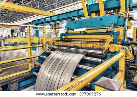 Cold rolled steel coil on decoiler of machine in metalwork manufacturing.