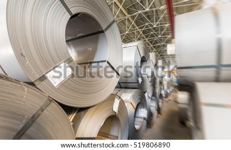 Steel coils stacked in a warehouse.