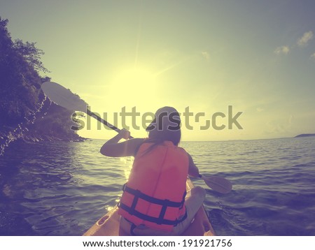 Filtered image : Girl with paddle and kayak  kayaking in sea