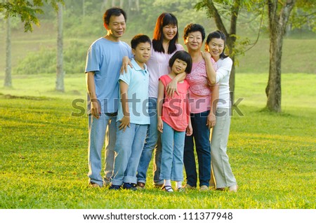 Extended family standing outdoors smiling
