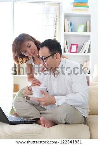 asian couple surfing internet lifestyle photo on sofa, chinese persons