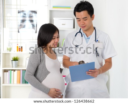 asian doctor having discussion with pregnant mother