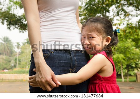 little asian girl crying and hugging her mother