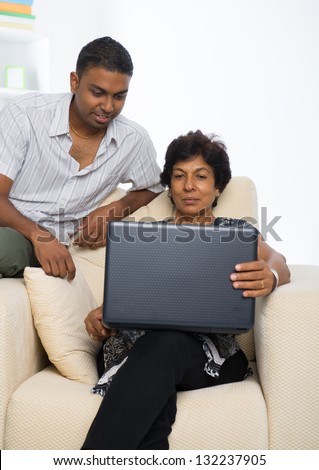 indian family ,mother and son surfing the internet using laptop photo