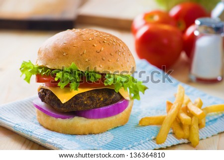 cheese burger , french fries and fast food with plenty of raw materials on the background