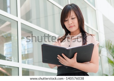 asian chinese female student in formal wear writing A portrait of an Asian college student on campus