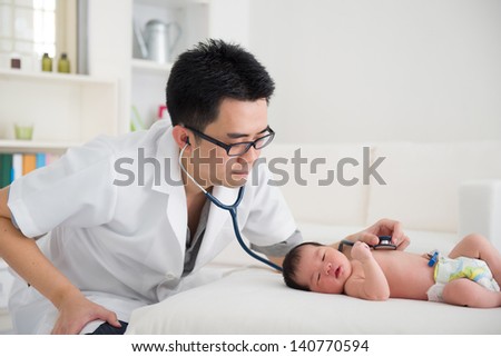 Good looking asian doctor and newborn baby on the clinic , monitoring heart rate