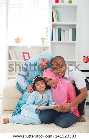 malay family using tablet having a good time surfing internet