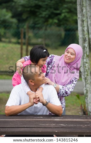 malay muslim family having fun in the park