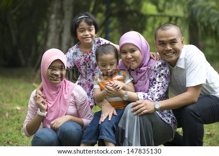 malay muslim family having fun in the park