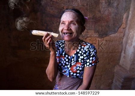 Old Asian woman smoking tobacco. Bagan, Myanmar.