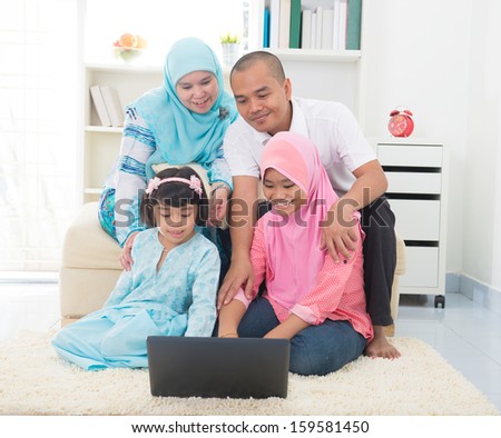 malay indonesian family surfing internet at home.