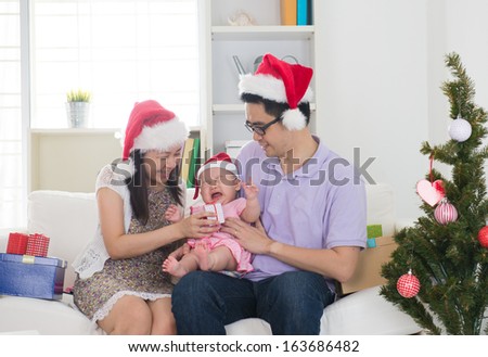 Asian chinese young family celebrating christmas with baby crying