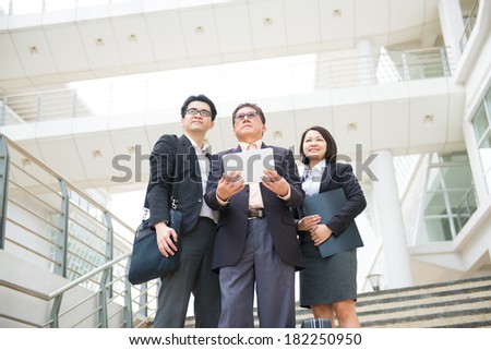 asian business team in a reporting meeting with office background