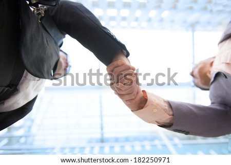 Close up image of hand shake against skyscrapers, low angle