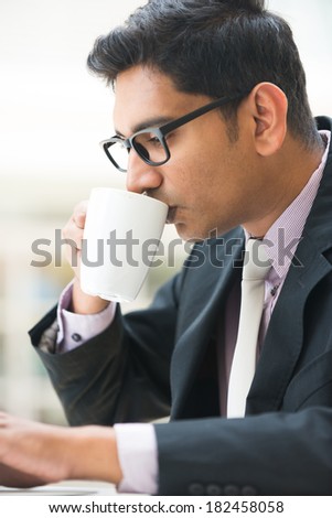 close up of young indian business man enjoying coffe during work
