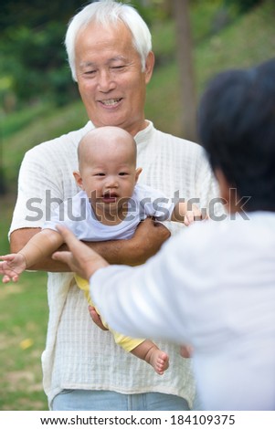 chinese grandparents playing with baby grandson at outdoor