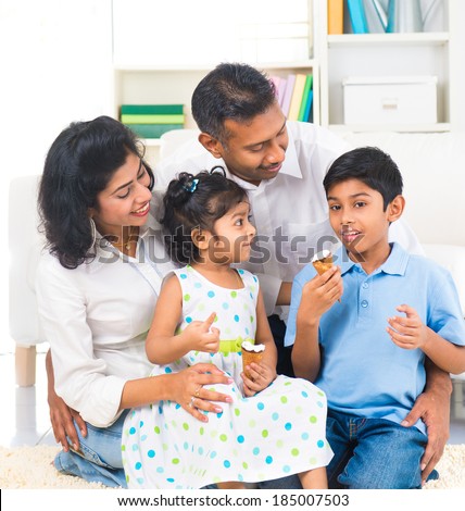 happy indian family enjoying eating ice cream indoor