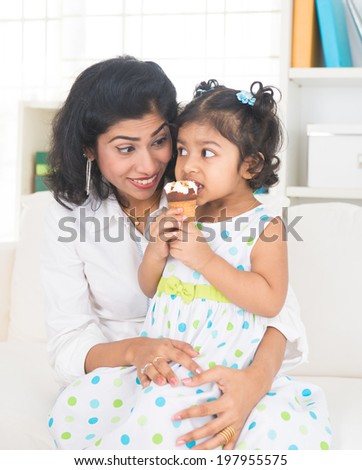 indian mother enjoying ice cream with her daughter on lifestyle background
