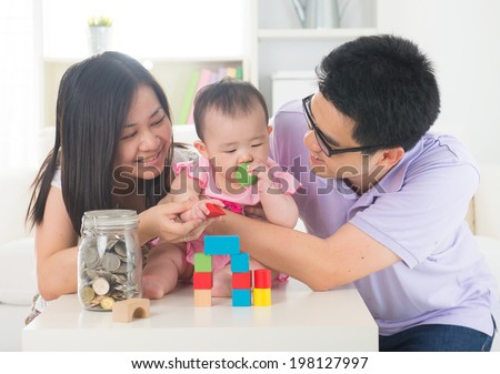 asian parent playing with baby girl in livingroom