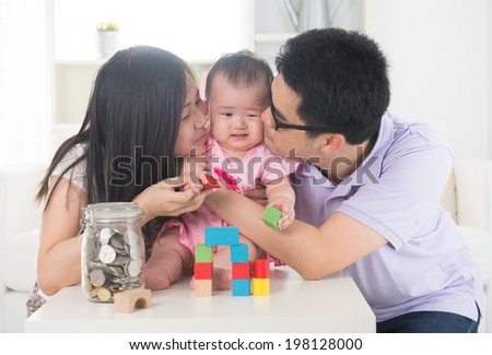 asian parent playing with baby girl in livingroom