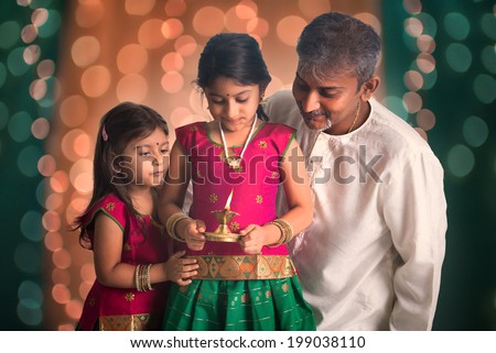 indian family fagther and daughter celebrating diwali ,fesitval of lights inside a temple