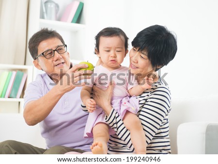 asian grand parents comforting their spoilt crying grand daugther