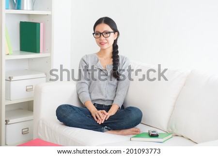 young asian woman watching tv in the room