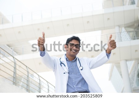 indian male doctor celebrating success in outdoor hospital