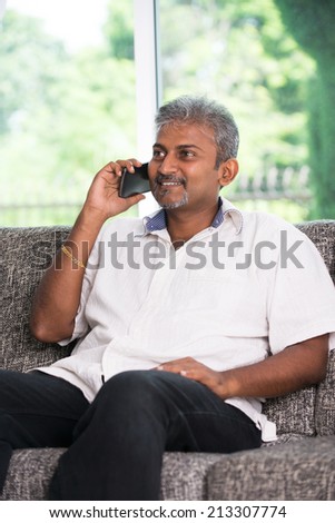 indian mature male on phone conversation with lifestyle background
