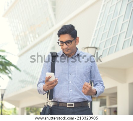 happy young indian business man on a smartphone light vintage tone