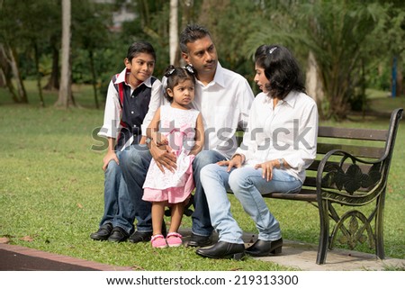 indian family sitting on the bench in the park