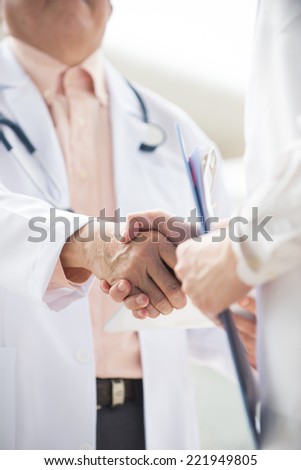 Close up  photo Asian medical team of doctors shaking hands inside hospital building
