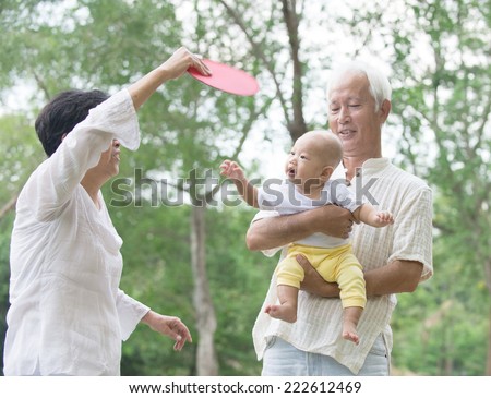 asian grandparents playing with baby grandson at outdoor