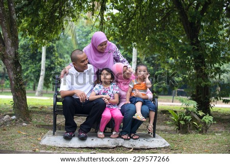 Happy Malay Asian Family enjoying family time together in the park