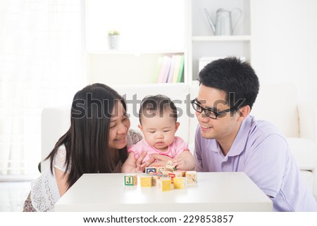 chinese parent playing with baby