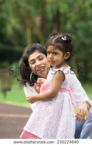 Happy Indian mother and daughter playing in the park. Lifestyle image.