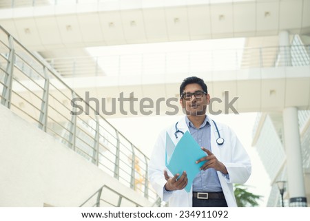 indian male doctor reading report, slight vintage tone