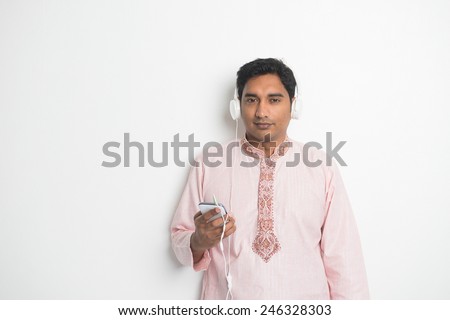 Traditional Young Indian Asian Male College Student listening music with headphones