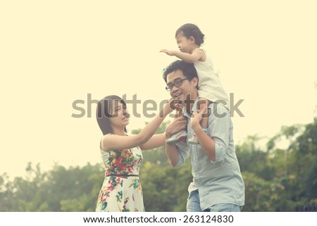 asian family playing and enjoying quality time outdoor , vintage tone