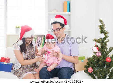 asian parents celebrating christmas with baby